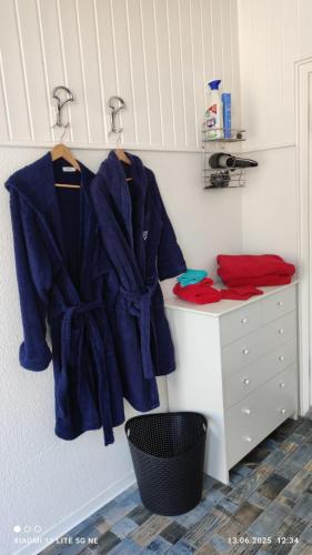 a bathroom with blue coats hanging on a wall at "Saunahotel" mit separatem Badezimmer in Meinerzhagen