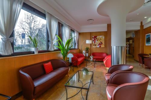 a waiting room with leather couches and chairs at Hotel Bologna Airport in Bologna