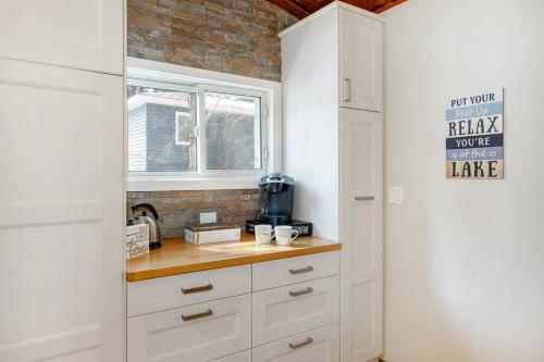 een keuken met witte kasten en een raam bij Lovely Little Lake House in Brighton