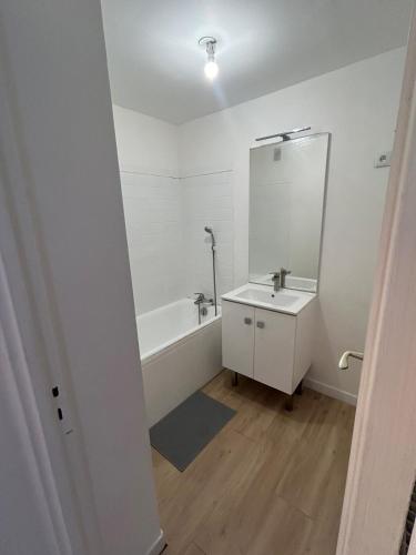 une salle de bain avec une baignoire, un lavabo et un miroir dans l'établissement Apartment 8 min Orly, 2 min RER, bus direct Orly, à Ablon-sur-Seine