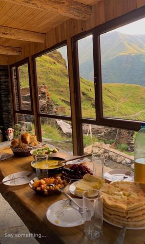 a table with food on it with a view of a mountain at Guesthouse Kvavlo in Kvavlo