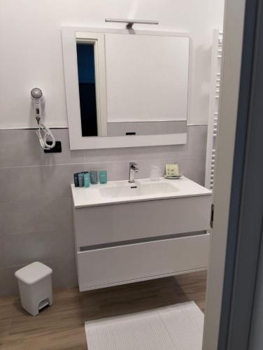 a white bathroom with a sink and a mirror at Fishermen Bros in Francavilla al Mare