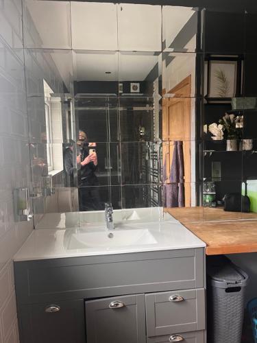una persona tomando una foto de un lavabo del baño en Double ground floor room - Leicester free parking and drinks, en Leicester