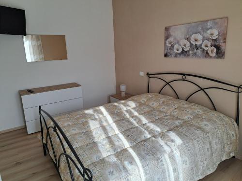 a bedroom with a bed and a painting on the wall at La casa di Memy in Gualdo Tadino