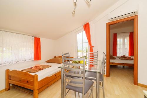 a bedroom with a bed and a chair and a mirror at Kuca Orhidea in Crikvenica