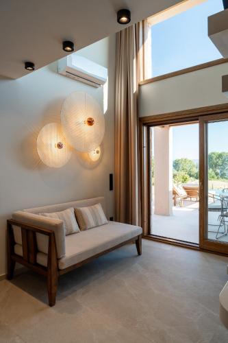 a living room with a bed and a large window at Candelas Suites & Nature in Ierissos