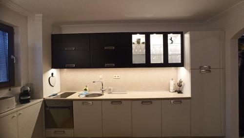 a kitchen with white cabinets and a sink and a window at Premium Oasis Beach Club Apartment in Lozenets