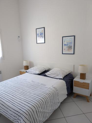 une chambre avec deux lits et deux tableaux au mur dans l'établissement Maison de vacances climatisée 600m de la mer Cour privative et parking, à Port-la-Nouvelle