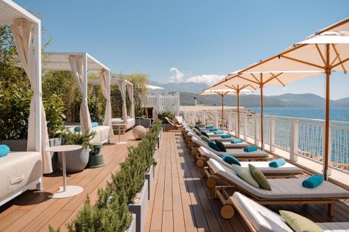 a row of lounge chairs and umbrellas on a balcony at Lustica Bay Marina Village by 2BHome in Lustica