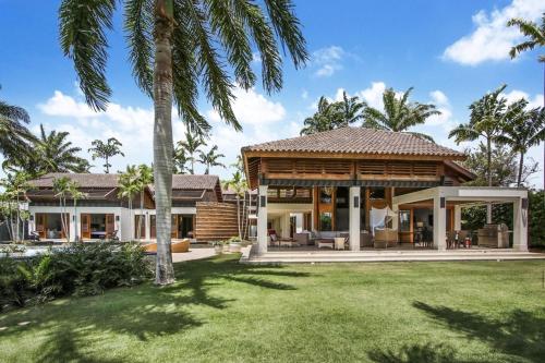 a house with a pavilion in a yard with palm trees at Casa del Sol in La Romana