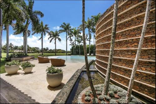 a pool with palm trees next to a building at Casa del Sol in La Romana