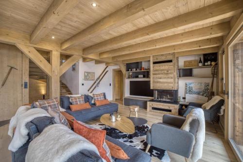 - un salon avec des canapés bleus et un plafond en bois dans l'établissement Chalet familial vue MontBlanc, à Saint-Gervais-les-Bains