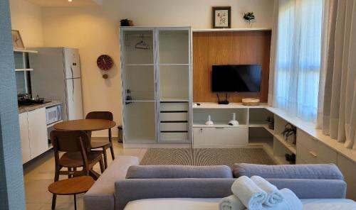 a living room with a blue couch and a tv at Blend Coliving One - 2b in Ribeirão Preto