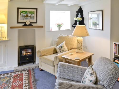 - un salon avec un canapé et une cheminée dans l'établissement Swiss Cottage, à Rievaulx