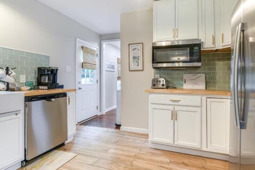 a kitchen with white cabinets and stainless steel appliances at Walk to Town and River Charming Home in North East! in North East