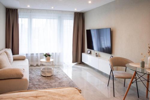 a living room with a couch and a flat screen tv at Stylisches City Apartment, nähe MB Werk, Top Ausstattung, Zentral und Sonnig in Sindelfingen