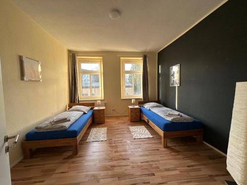 a room with two beds and two windows at Schöne 3 Schlafzimmer Wohnung Philipp1 in Plauen