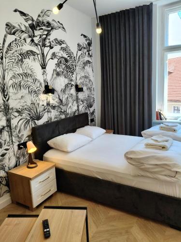 a bedroom with two beds and a wall with plants at Drzewna Apartamenty-Żeromskiego, Stare Miasto in Zielona Góra