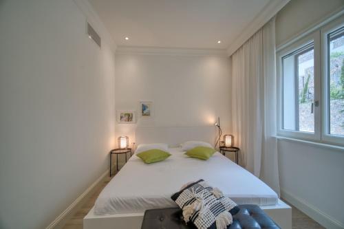 a white bedroom with a large bed and a window at Lustica Bay Marina Village by 2BHome in Lustica