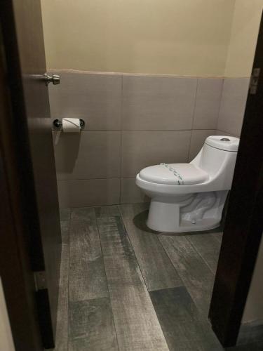 a bathroom with a toilet in a bathroom stall at Hotel Boutique Querencia in Tijuana