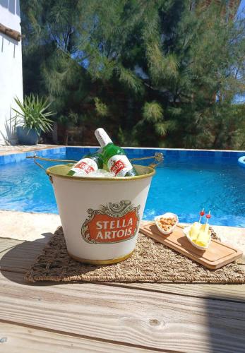 a bucket of beer sitting on a table next to a pool at Bangalô Exclusivo Pontal do Maceió in Maceio