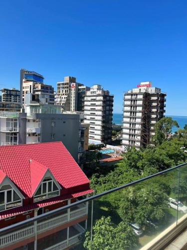 a building with a red roof in a city at Apartment in Gonio - PONTOS ROOMS in Itʼkhvisi