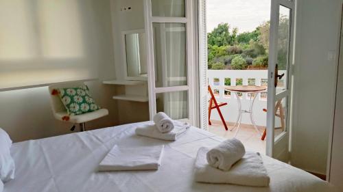a bedroom with towels on a bed with a balcony at Tarmaros - Families & Groups in Sissi