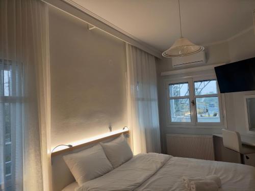 a bedroom with a white bed and a window at Tarmaros - Families & Groups in Sissi