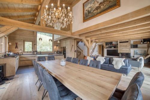 une salle à manger et une cuisine avec une grande table et des chaises en bois dans l'établissement Chalet familial vue MontBlanc, à Saint-Gervais-les-Bains