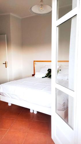 a bedroom with a white bed and a mirror at Tarmaros - Families & Groups in Sissi