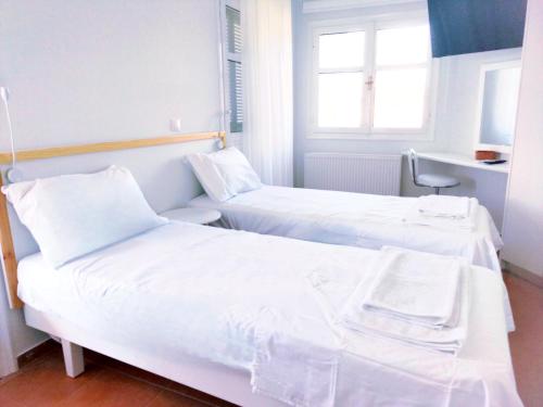 two beds in a hotel room with white sheets at Tarmaros - Families & Groups in Sissi