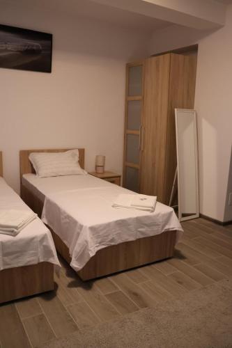a bedroom with two beds and a cabinet at Parlament Residence in Bucharest