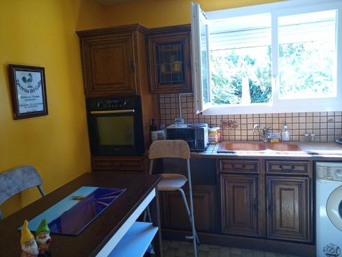 une cuisine avec des armoires en bois, un évier et une fenêtre dans l'établissement Maison St Jean de Védas centre, à Saint-Jean-de-Védas