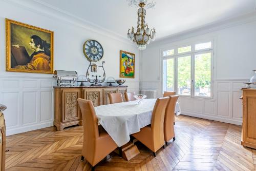 a dining room with a table and a clock on the wall at Casa La Palma Le 48 in Soissons
