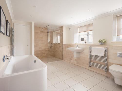 a bathroom with a tub and a toilet and a sink at Westhill House in Warkworth