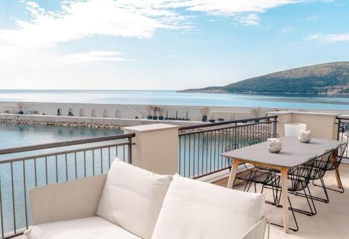 a balcony with a table and chairs and the ocean at Lustica Bay Marina Village by 2BHome in Lustica