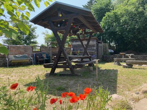 a picnic shelter in a garden with red flowers at Sonnenlandhof in Neuruppin