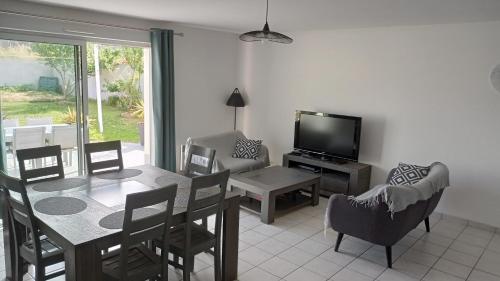 un salon avec une table à manger et une télévision dans l'établissement Le havre des Sables, à Les Sables-dʼOlonne