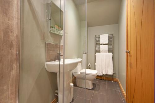 a small bathroom with a toilet and a sink at Oban House House in Oban