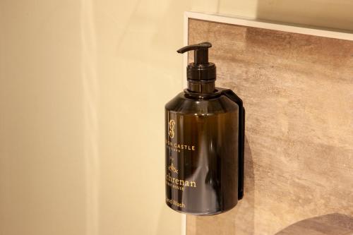 a black bottle is sitting on a wall at Oban House House in Oban