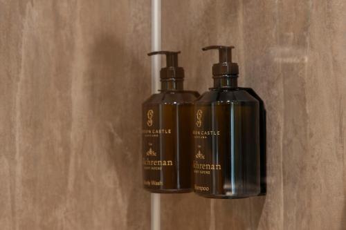 two bottles of soap sitting on a wall at Oban House House in Oban