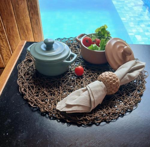 a table with a tea pot and a bowl of salad at Bangalô Exclusivo Pontal do Maceió in Maceio