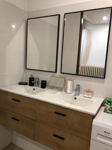 une salle de bain avec deux lavabos et deux miroirs dans l'établissement Grands Jardins Cottage Charming countryside, à Sainte-Geneviève-lès-Gasny