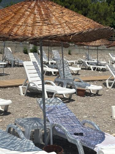 a group of chairs and umbrellas on a beach at MOY Beldibi Hotel in Antalya