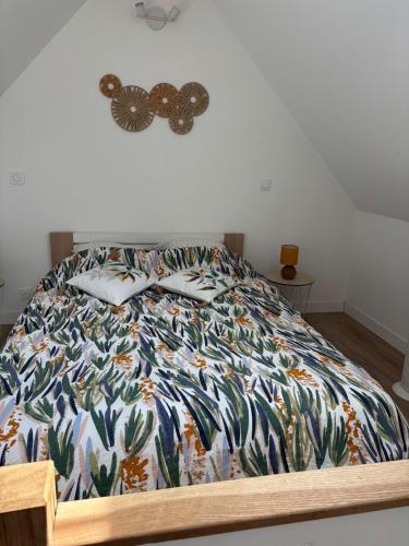 - un lit avec une couette colorée dans une chambre dans l'établissement Grands Jardins Cottage Charming countryside, à Sainte-Geneviève-lès-Gasny