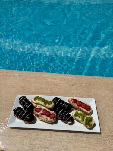 a plate of food next to a swimming pool at MOY Beldibi Hotel in Antalya