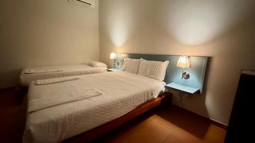 a hotel room with a bed and two lamps at Raízes da Vinha - Quartos & Chalé na Serra da Estrela in Carragozela