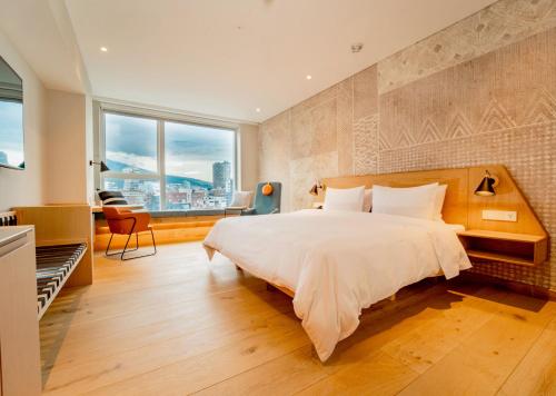 a bedroom with a large bed and a large window at GO Quito Hotel in Quito