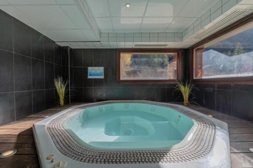 a jacuzzi tub in a room with plants at l'Ours Bleu B33 ski -in ski -out - Happy Rentals in Vallorcine