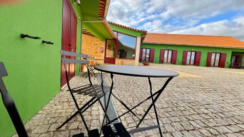 a table sitting in front of a building at Raízes da Vinha - Quartos & Chalé na Serra da Estrela in Carragozela